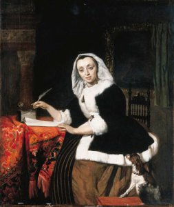 An elegant lady writing at her desk, with a dog beside her